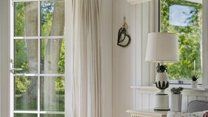 A room with a large window, a white lamp, a small plant, and a decorative heart hanging on the wall. - "Stig" - 1.1km from the sea by Interhome (Hornbæk)