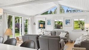 A spacious room with a high ceiling, large windows, and a cozy seating area with a sofa and chairs. - "Stig" - 1.1km from the sea by Interhome (Hornbæk)