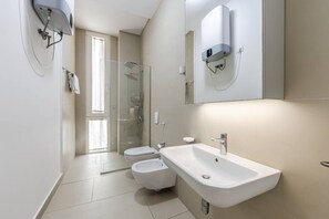Un baño moderno con ducha, inodoro y lavamanos.