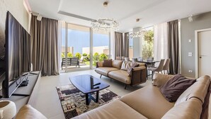 Ein modernes Wohnzimmer mit Sofa, Couchtisch und Essbereich mit Stühlen.
