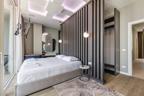 Un dormitorio moderno con una cama grande, un espejo, un armario y una lámpara en el techo.