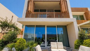 Ein modernes, zweistöckiges Gebäude mit Balkon, großen Fenstern und Außenbereich.