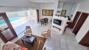 Amplia sala de estar con mesa de comedor, sillas, sofá y televisor.