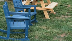 A wooden picnic table and chairs in a grassy outdoor area. - Gorgeous tiny home with mountain views in peaceful Candler (Candler)