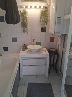 A small bathroom with a white sink, a mirror, a towel rack, a small stool, and a plant. - House Cocoon paradise in the North direct metro Lille ideal for groups! (Roubaix)