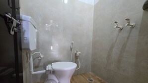 Een badkamer met een toilet, een douche en een wastafel.