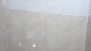 Een kleine, schone badkamer met toilet, hygiëneschuimer en douchekop.