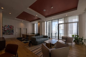A spacious living area with a sofa set, a dining table, and a large window offering a city view. - New Boutique Studio | 2 Guests | Downtown Miami (Miami)