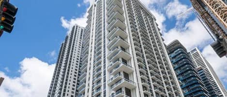 Un immeuble de grande hauteur doté de nombreux balcons, présentant un design architectural moderne et surplombant un ciel dégagé.