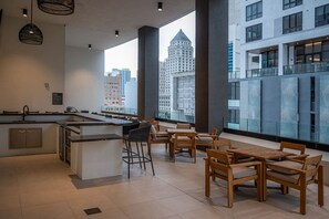 Eine moderne Küche mit Bar, großen Fenstern und Blick auf die Stadt sowie einer Sitzecke mit Holzmöbeln.