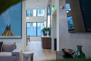 Ein modernes Interieur mit Küchenbereich, Essbereich und großem Fenster mit Blick auf die Stadt.