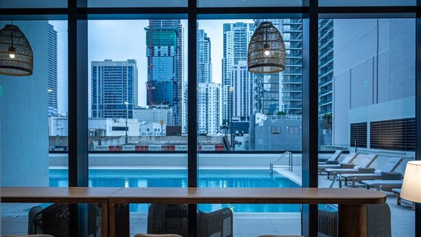 A poolside bar with chairs and a view of a cityscape through large windows. - FREE Parking • Corner Unit • Bay & Brickell Views (Miami)
