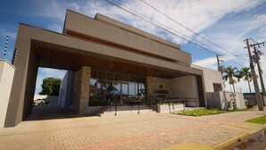 A modern building with a large entrance, stone pillars, and a paved walkway. - MANTRA HOTEL (Vera)