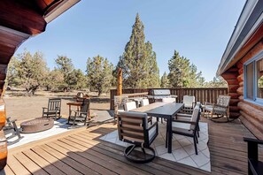 A wooden deck with outdoor furniture, a grill, and a fire pit. - Log Home w/view, Ping Pong, Cornhole, Gas FirePit! (Bend)