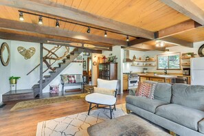 A spacious living area with a staircase, a sofa, a chair, and a kitchen area. - 2 Cabins! Sleeps 17, Ping Pong, Gas Fire Pit & BBQ (Arnold)