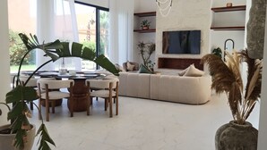 Un salon moderne avec un coin repas, une grande fenêtre et une cheminée.