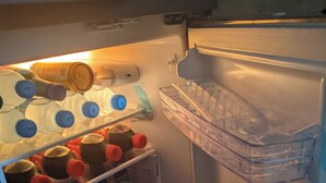 An open refrigerator with shelves stocked with milk, juice, and condiments. - Anna Luxury Lodge - Arusha  (Arusha)