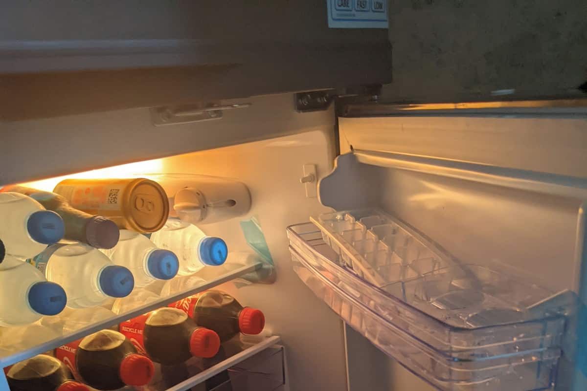 Un refrigerador abierto con estantes llenos de leche, jugo y condimentos.