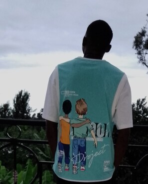A person wearing a teal and white shirt with a graphic design on the back. - Anna Luxury Lodge - Arusha  (Arusha)