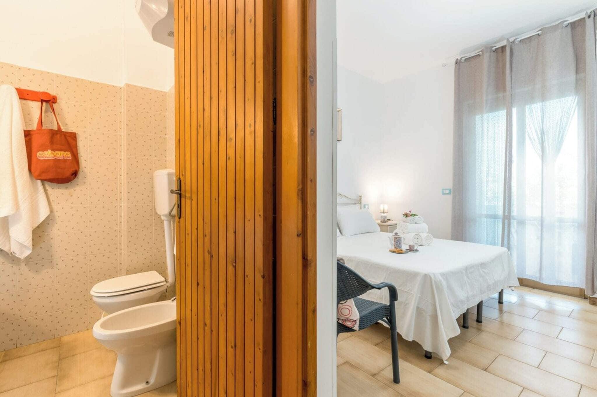 Un bagno con il water, un porta asciugamani e una zona doccia.