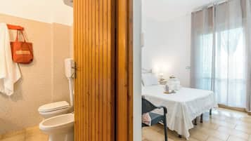 Un bagno con il water, un porta asciugamani e una zona doccia.