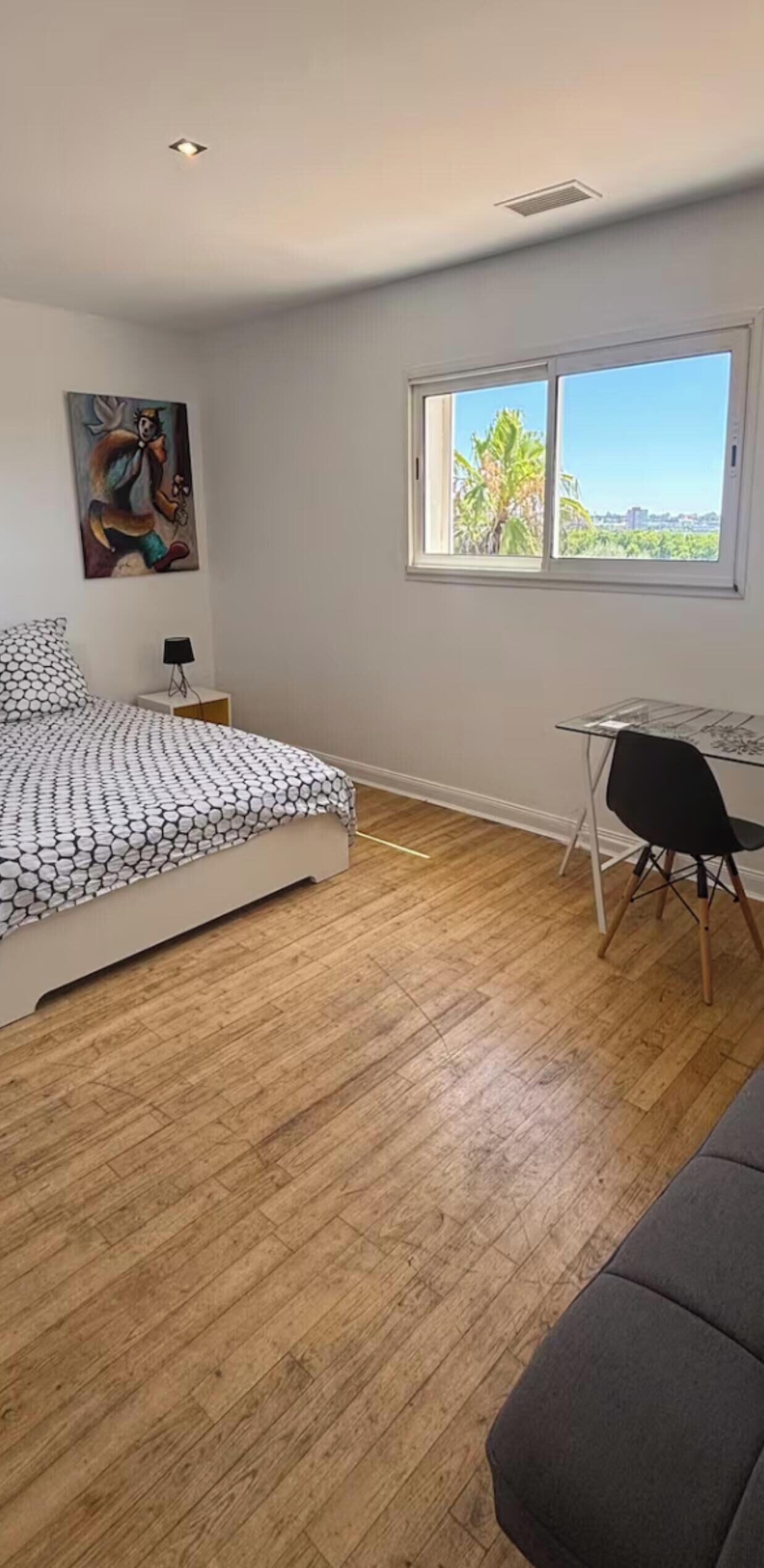 Ein Schlafzimmer mit einem Bett, einem Schreibtisch und einem Fenster.