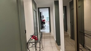 A hallway with a glass table, a red toy, and a door leading to another room. - La salamandre Pavilion facing the golf course (Juvignac)