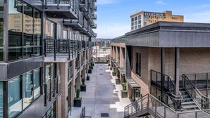 A multi-story building with a central courtyard, balconies, and a visible sign for 'STERCHI'S'. - Summit Hill Stay | King Suite | Free Parking (Knoxville)