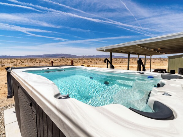 A hot tub in an outdoor setting with a desert landscape in the background.