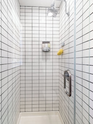 Une douche Ă©quipĂ©e dâun pommeau de douche Ă main, dâun autre pommeau de douche Ă main et dâun troisiĂšme pommeau de douche Ă main.