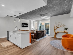 A modern interior with a kitchen island, dining area, and seating. - The Summit Nest | Cozy 1BR in the Heart of Knox (Knoxville)