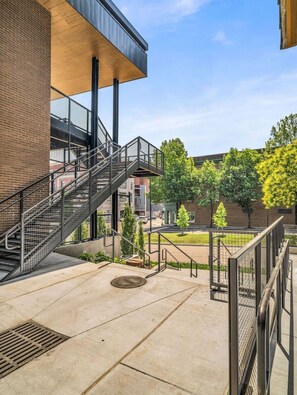 Ein Gebäude mit Backsteinfassade und Metalltreppe, bewölkter Himmel.