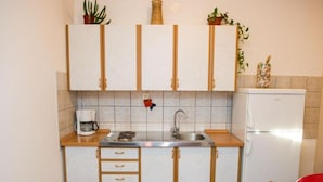 Una cocina pequeña equipada con fregadero, estufa y refrigerador.
