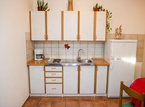 Eine kleine Küche mit Spüle, Herd und Kühlschrank.