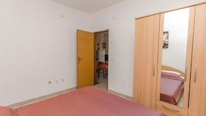 Un dormitorio con una cama, un armario y una puerta que da a otra habitación.