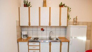 Eine kleine Küche mit Spüle, Herd und Kühlschrank.