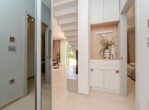 Ein modernes Hotelzimmer mit einer großen Schiebetür, einem Holfachschrank, einem kleinen Tisch und einem Blumentopf.