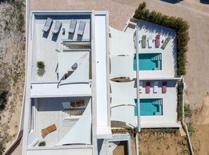 Eine moderne Villa mit Dachterrasse, Swimmingpool und einer Treppe zu den oberen Ebenen.