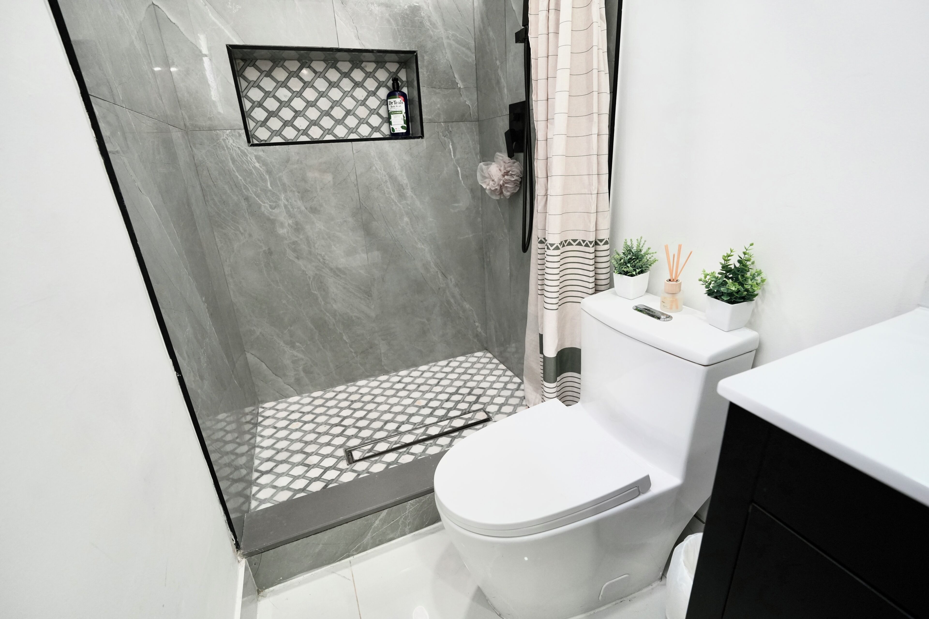 A bathroom with a shower, toilet, and sink.