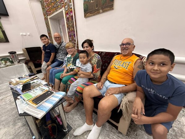 Una familia sentada en un sofá con una mesa frente a ellos.