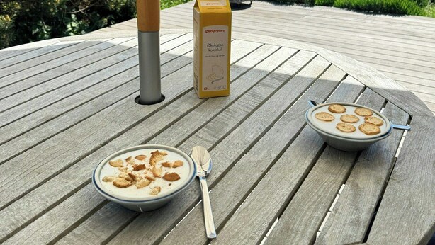 Un molo di legno con un tavolo apparecchiato per la colazione, con cereali e latte, e una confezione di latte.