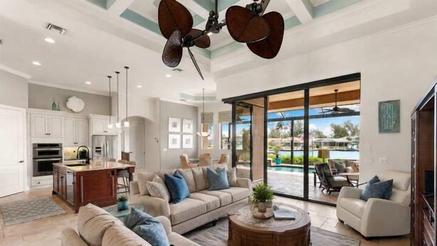 A spacious living room with a large sofa, a coffee table, and a dining area. - Marco Island Bayfront Pool & Spa (Marco Island)