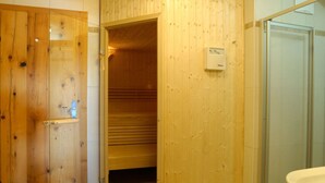 A wooden interior with a sauna, a glass shower enclosure, and a visible sauna control panel. - Ski Lodge in Krimml With Swimming Pool (Krimml)
