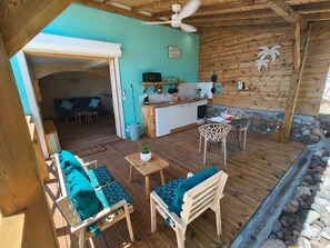 Ein gemütliches Blockhaus mit einer Holzdiele, einer Küche und einem Wohnbereich mit einer Couch und Sesseln.