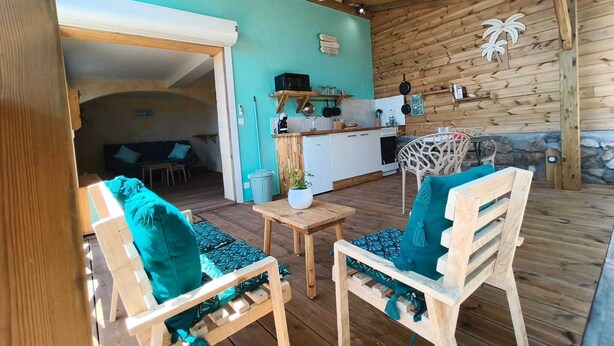 A wooden interior with a kitchen area, a dining table with chairs, and a ceiling fan. - Caribbean Beach Studios. Ti Colibri Studio near the beaches in Ferry-Deshaies (Deshaies)