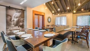 A dining area with a long table set for multiple people, a wooden ceiling, and a large framed picture on the wall. - Emotions by Hodelpa - Juan Dolio (Juan Dolio)