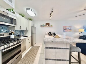 Eine moderne Küche mit einer zentralen Kochinsel, Edelstahlgeräten und einer strukturierten Spritzschutzküchenwand.