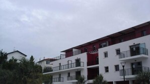 Un edifici d'apartaments de diversos pisos amb balcons i terrassa plana.