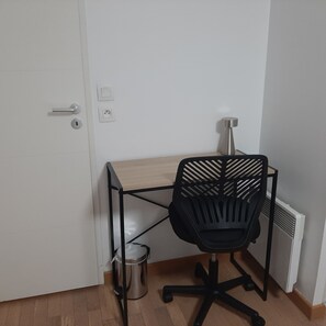 Ein kleiner Büroraum mit Schreibtisch, Stuhl und Heizkörper.