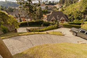 Bairro residencial com casas, entrada de automóvel de cascalho e um veículo estacionado.